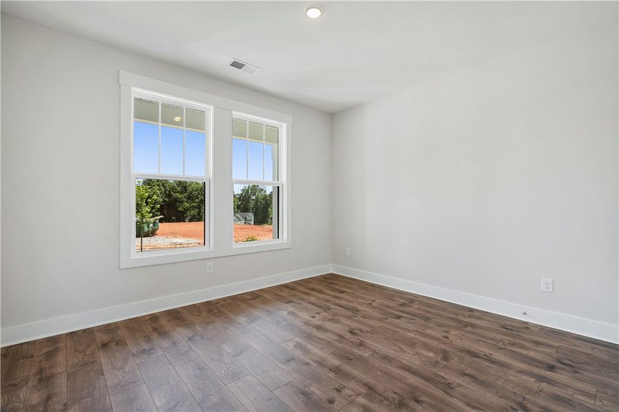 Well-lit room features rich hardwood flooring and
