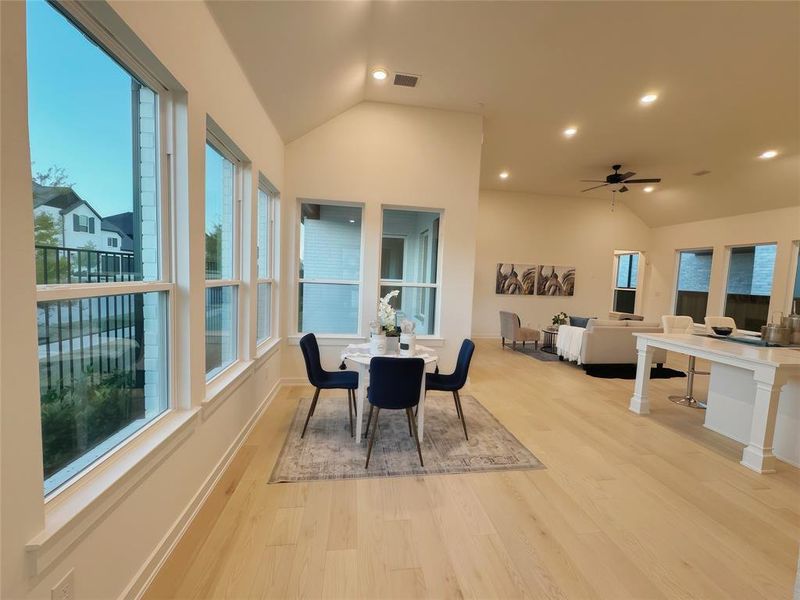 Dining area featuring lofted ceiling, light wood-type flooring, and a healthy amount of sunlight