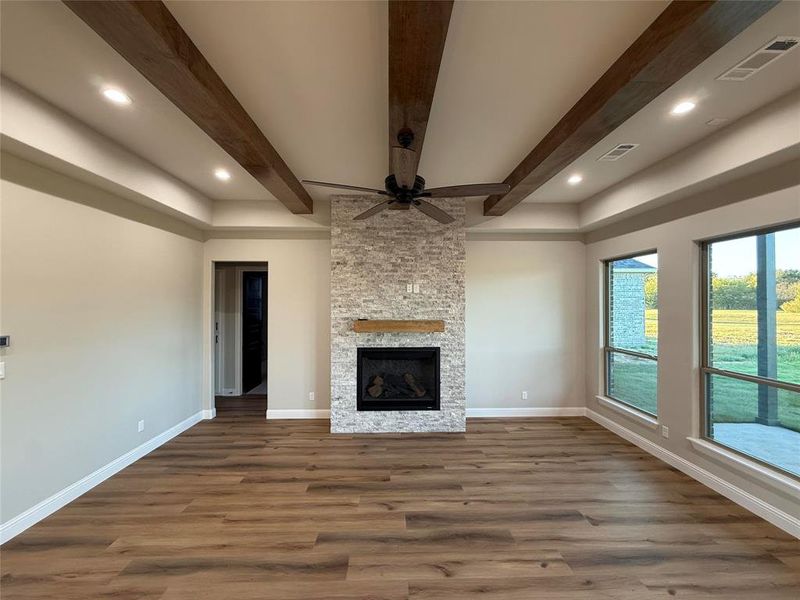 Unfurnished living room featuring dark wood finished floors, a fireplace, beamed ceiling, recessed lighting, and ceiling fan Unfurnished living room featuring dark wood finished floors, a fireplace, beamed ceiling, recessed lighting, and ceiling fan