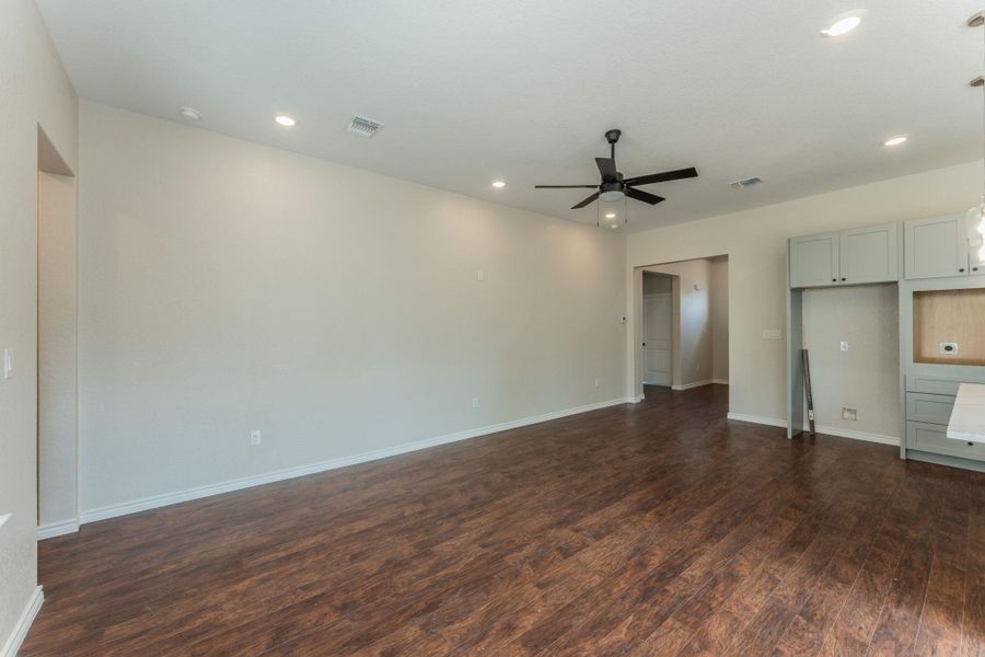 Open-concept living space featuring wood-finish flooring, recessed lighting, and a modern ceiling fan