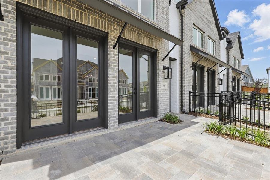 Property entrance featuring french doors, brick siding, and a patio area