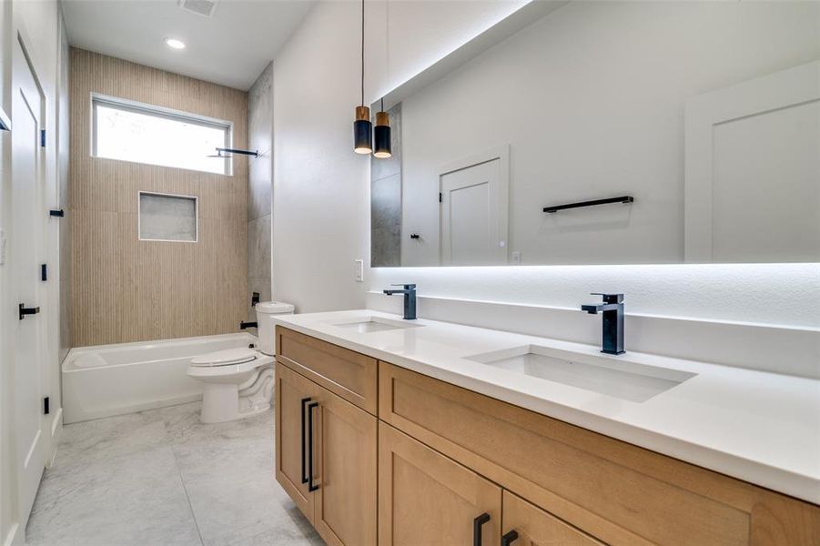 Full bath with double vanity and tub / shower combination