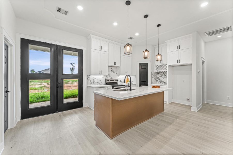 Spacious kitchen featuring abundant cabinetry, center island, and plenty of counter space for meal prep and gatherings. Photos are representative of the same floor plan built by this builder. Finishes will be the same or similar.