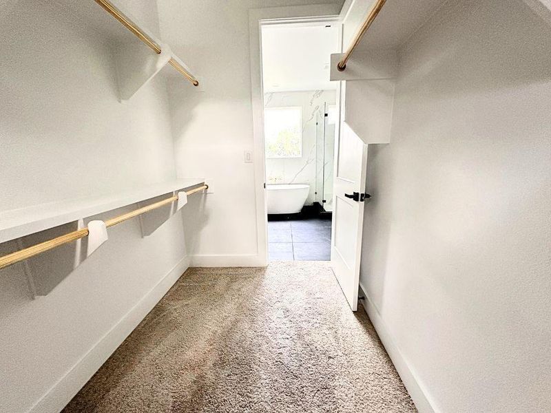 A spacious walk-in closet seamlessly connects to a refined bathroom retreat. A spacious walk-in closet seamlessly connects to a refined bathroom retreat.