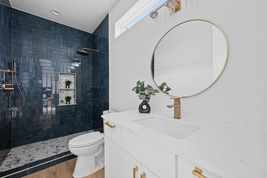 Bathroom featuring a white vanity with gold-tone hardware, a circular mirror, and a gold-tone faucet