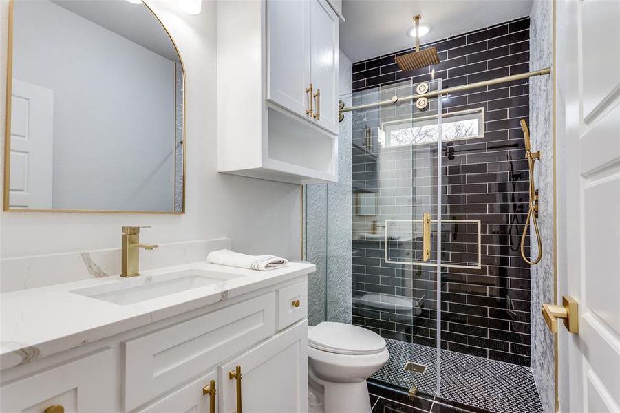 Bathroom featuring vanity, toilet, and a shower with shower door