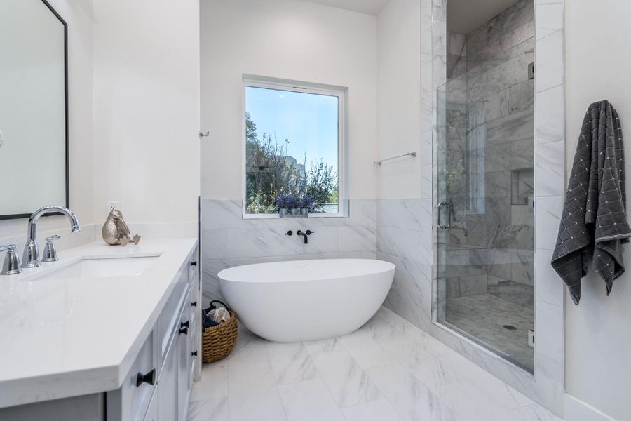 Light-filled primary bathroom showcasing a serene garden tub, separate walk-in shower, and refined finishes throughout. Light-filled primary bathroom showcasing a serene garden tub, separate walk-in shower, and refined finishes throughout.