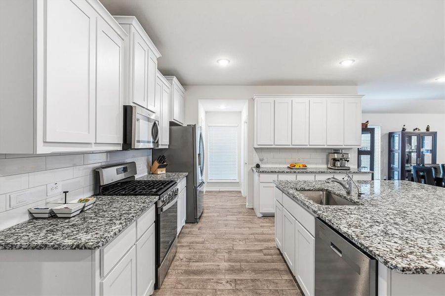 Beautifully updated kitchen featuring granite countertops, a gas range, abundant storage, a water purification system, and so much more.