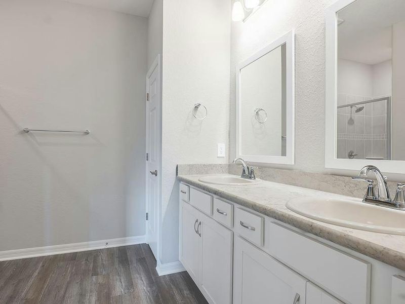 The suite is complete with a walk-in wardrobe and en-suite bath - Photos showcase a home with similar finishes, not the actual home for sale.