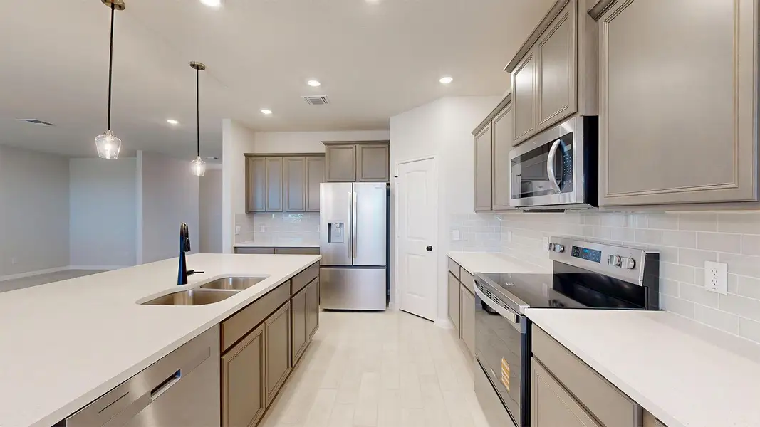 Kitchen with stainless steel appliances, decorative light fixtures, tasteful backsplash, and light stone counters