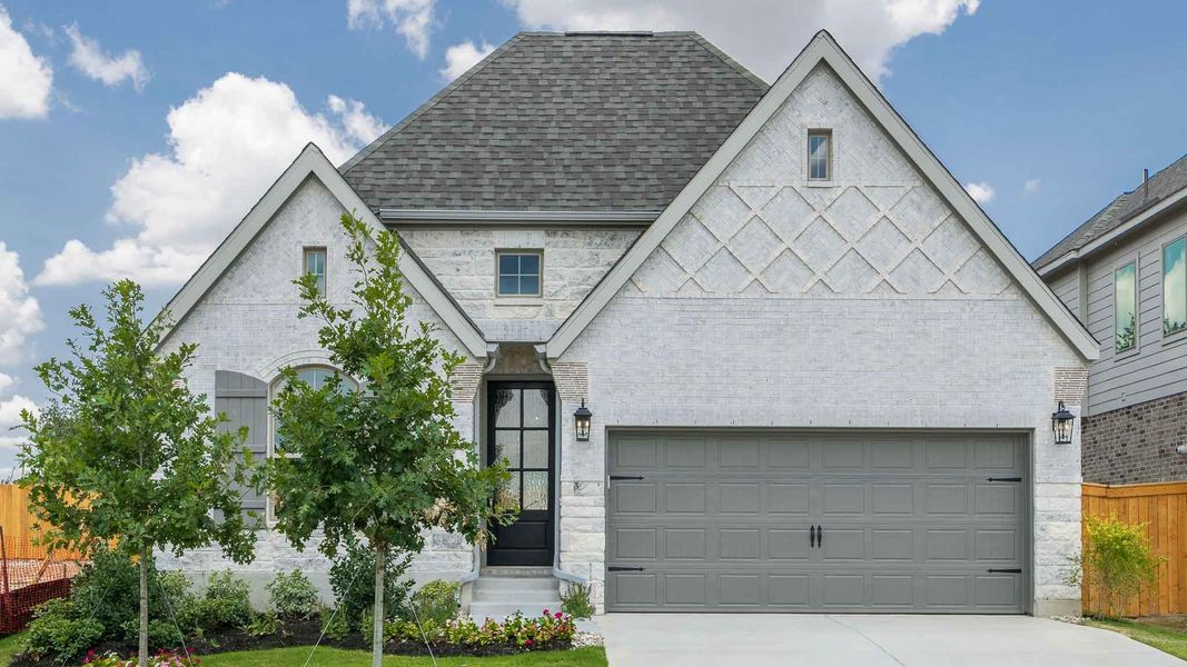 View of front of home with roof with shingles, concrete driveway, brick siding, and a garage
