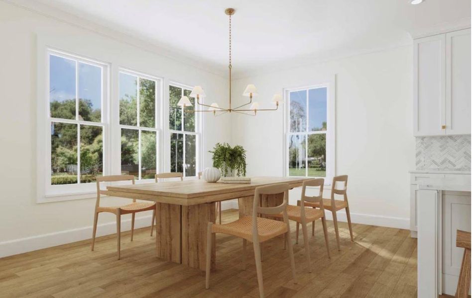 A naturally illuminated dining room boasts hardwood flooring and abundant natural light from multiple large windows.