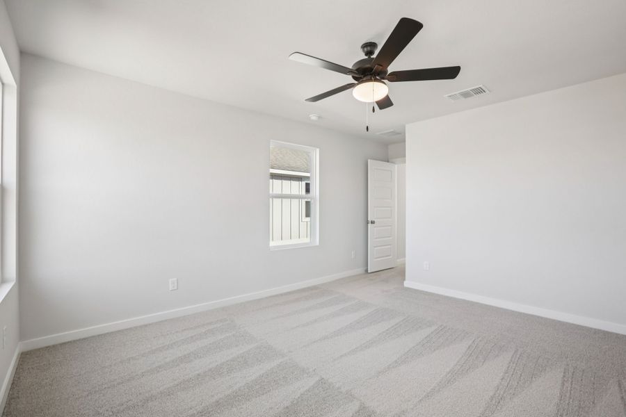 A room with a ceiling fan and a door.