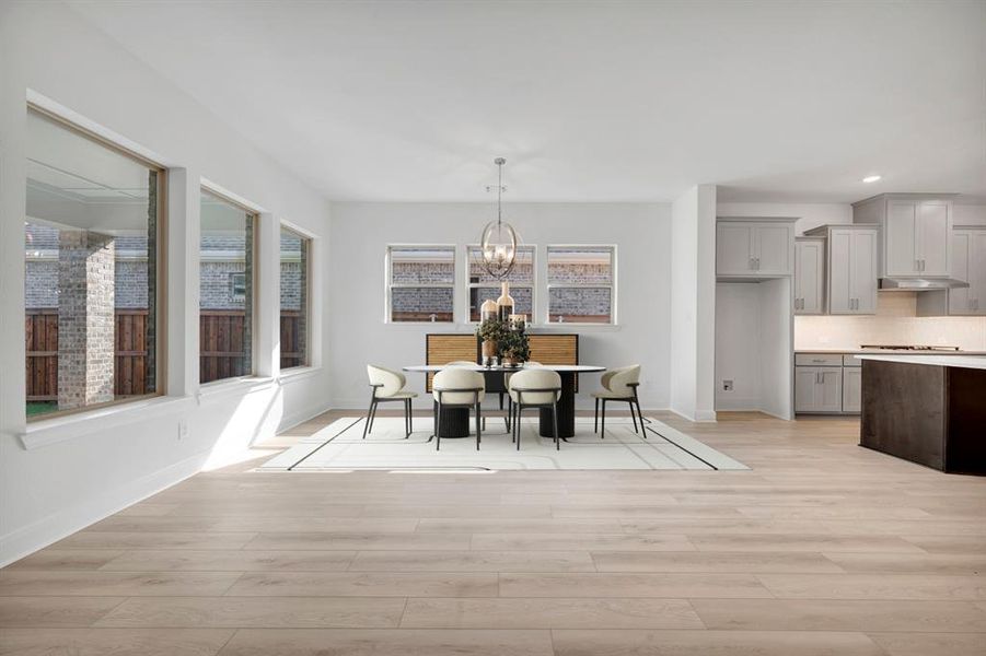 Dining room featuring light wood-type flooring and hanging lights Dining room featuring light wood-type flooring and hanging lights