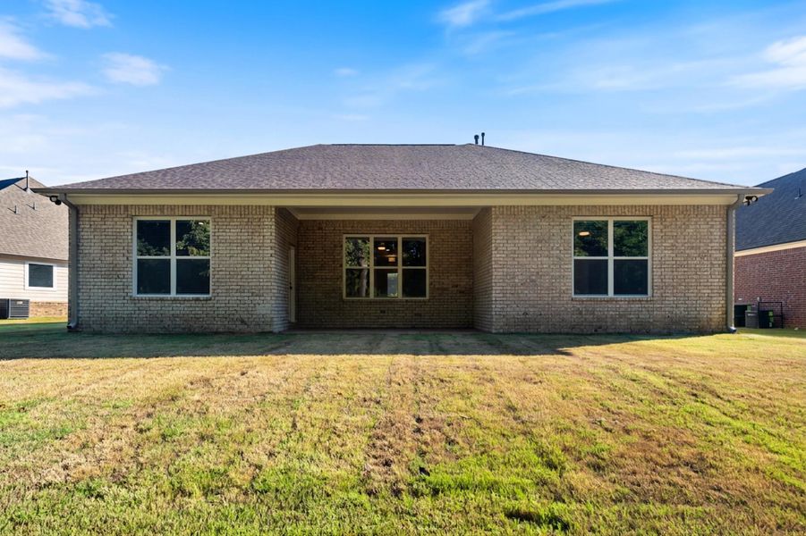 Brick exterior with a covered patio and multiple windows
