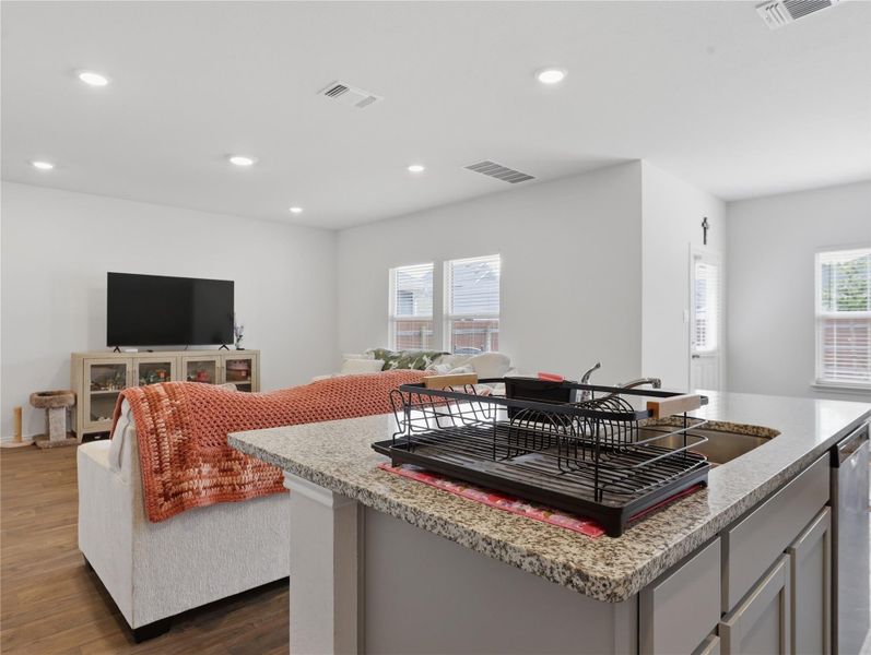 Granite countertops and wood floors define this open living and dining area. Granite countertops and wood floors define this open living and dining area.