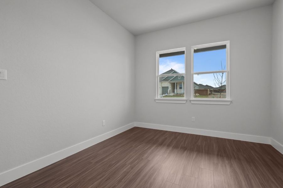 A room with a wood floor and a window with a view of the outside. A room with a wood floor and a window with a view of the outside.