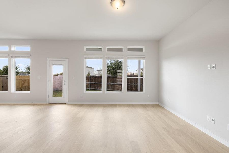 Empty room with light wood-style flooring and healthy amount of natural light