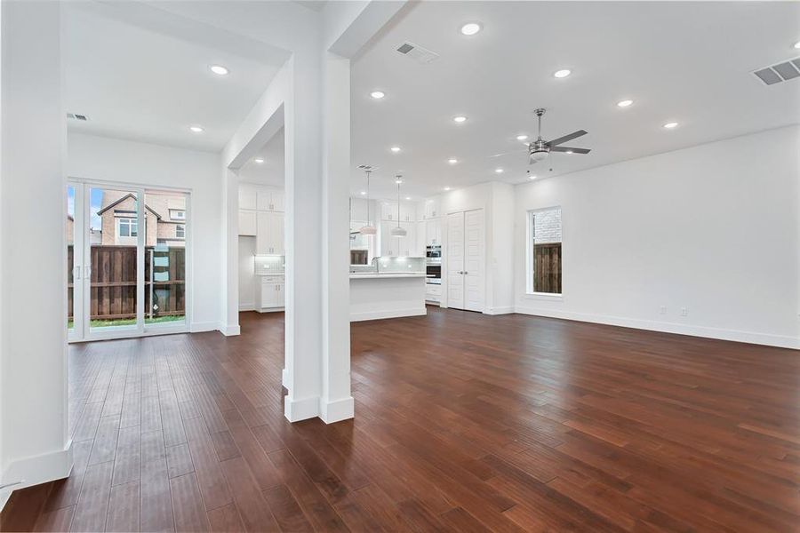 Unfurnished living room featuring dark wood-type flooring and ceiling fan