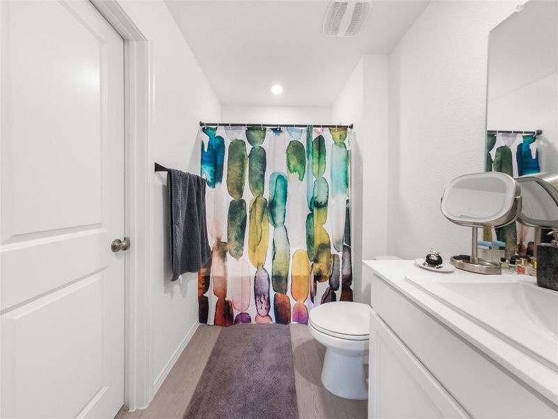 Bathroom featuring a shower with curtain, vanity, and light wood finished floors