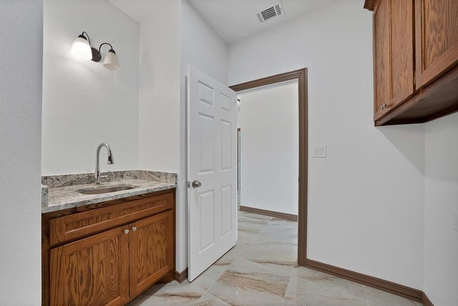 Bathroom featuring vanity and light marble finish flooring