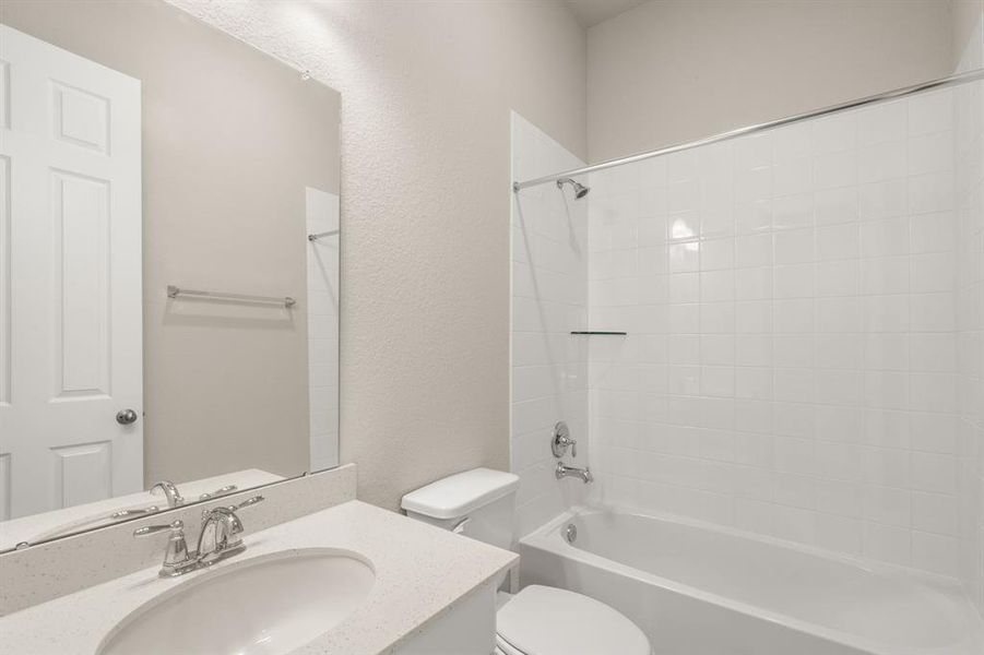 The secondary bath features tile flooring, white cabinetry and light countertops and a shower/tub combo. Perfect for accommodating any visiting family and friends.