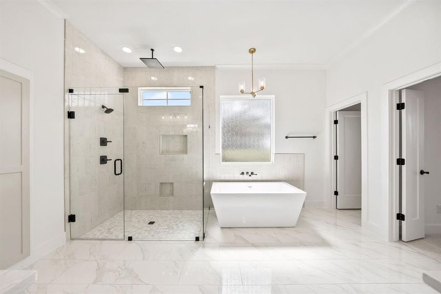 Bathroom featuring a shower stall, a freestanding bath, light marble finish floors, and a chandelier Bathroom featuring a shower stall, a freestanding bath, light marble finish floors, and a chandelier