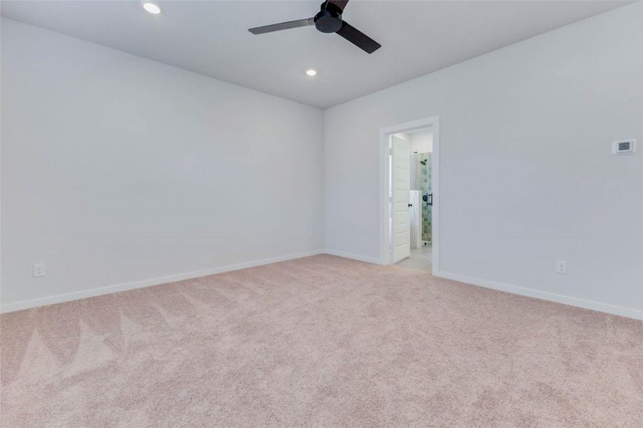 Retreat to the peaceful first-floor primary bedroom, where plush carpeting, recessed lighting, and a modern ceiling fan set the tone for rest and relaxation. Direct access to the ensuite bath makes this space the ultimate private getaway within your home.