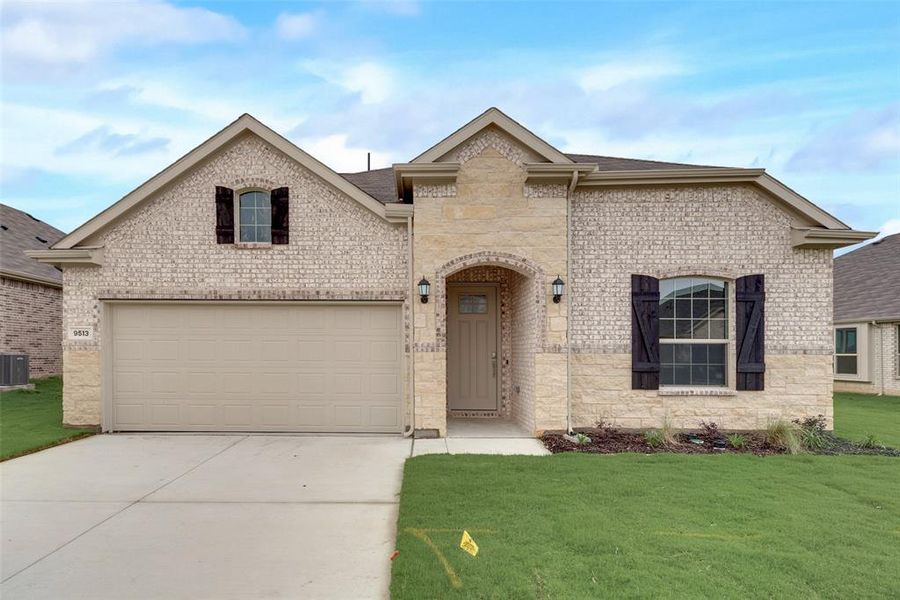 View of front of home featuring cooling unit, a garage, and a front lawn