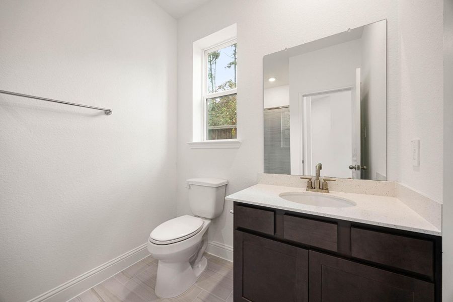 Bright and modern bathroom featuring a sleek vanity, elegant fixtures, and a large window for natural light.