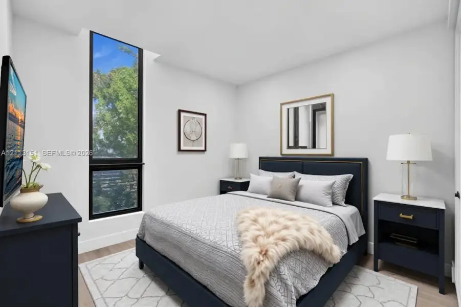 Floor-to-ceiling window featuring dark framing and wood-finish flooring Floor-to-ceiling window featuring dark framing and wood-finish flooring