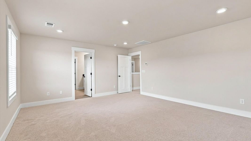 Elegant primary suite with tray ceiling and walk-in closet in this top-notch Walnut Ridge home