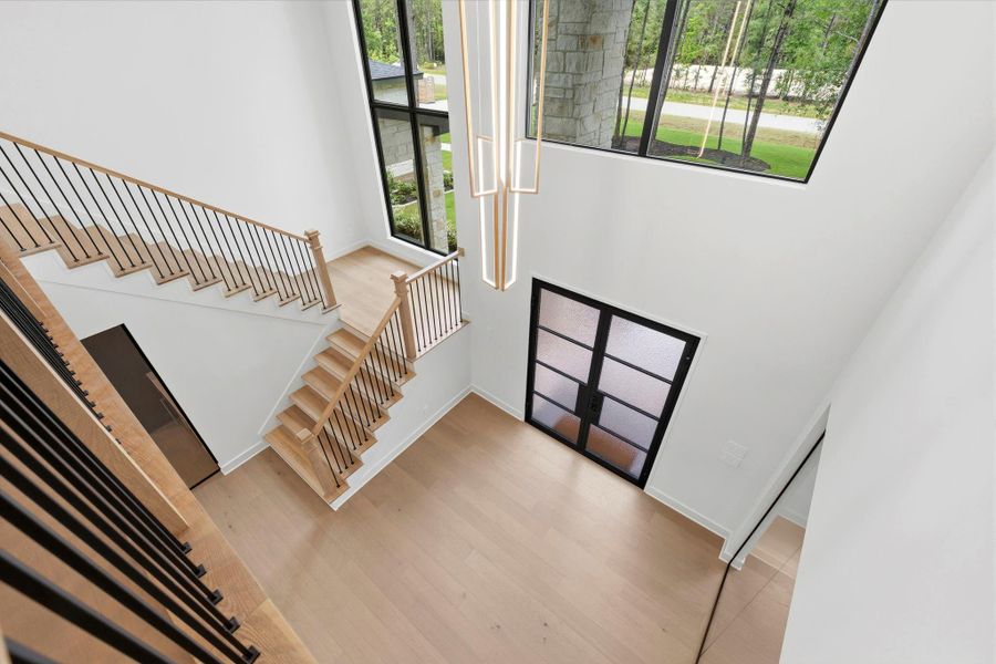 View from the upstairs CATWALK overlooking the entry, marking the transition to the home's SECOND level.