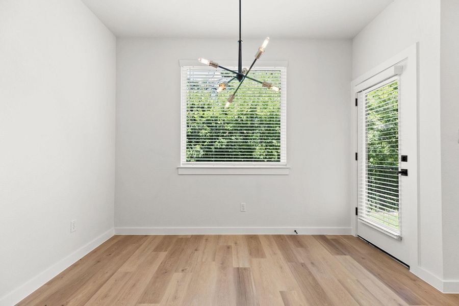 A well-lit room showcases modern light wood flooring and a distinctive contemporary light fixture. A well-lit room showcases modern light wood flooring and a distinctive contemporary light fixture.