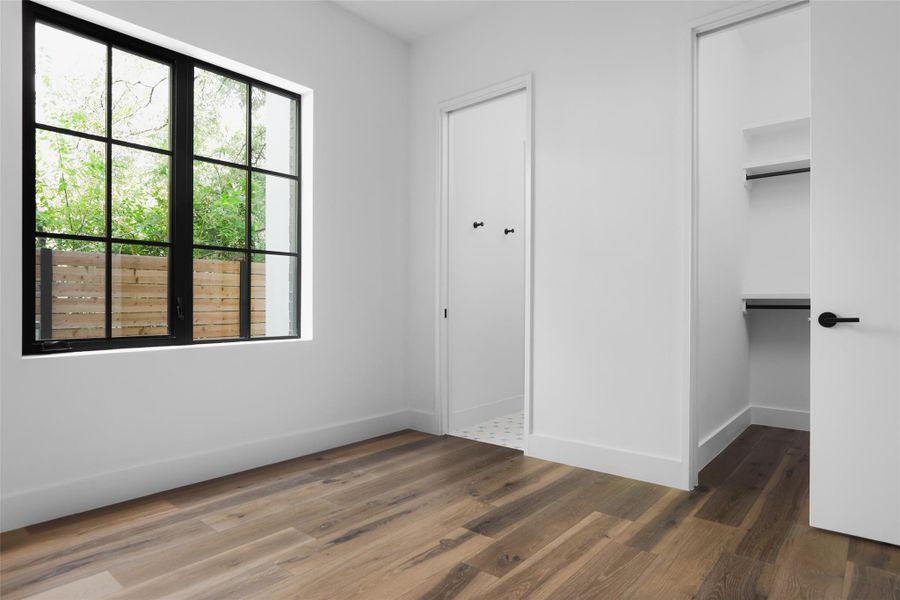 Addional guest room with wood flooring