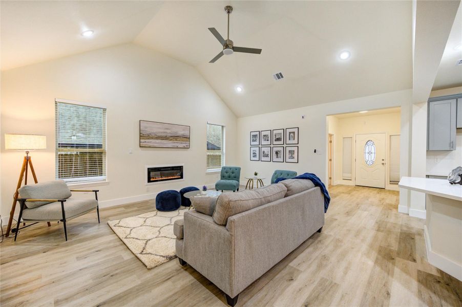 Spacious living room with modern design, featuring high ceilings, sleek flooring, and abundant natural light.