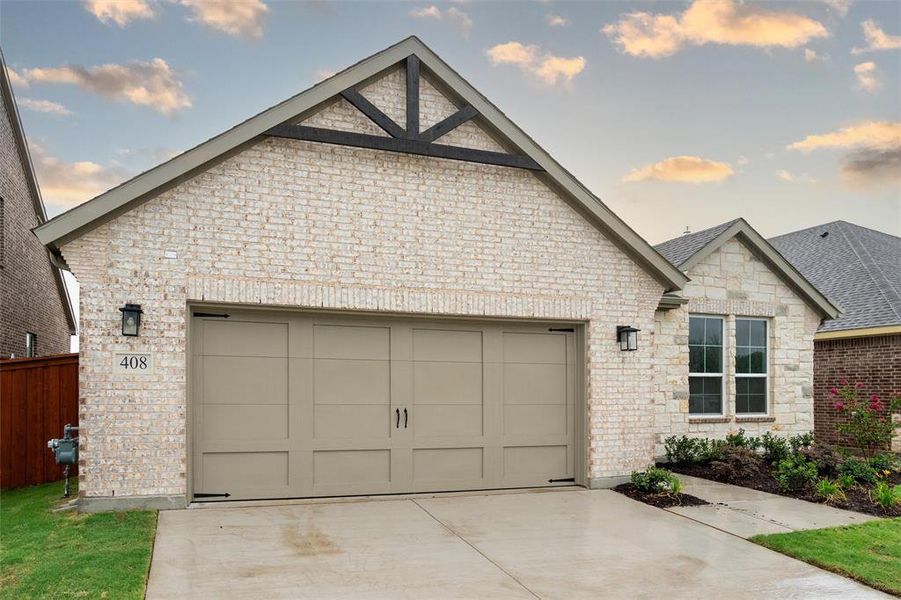 View of front of home featuring a garage, roof with shingles, driveway, stone siding, and brick siding View of front of home featuring a garage, roof with shingles, driveway, stone siding, and brick siding