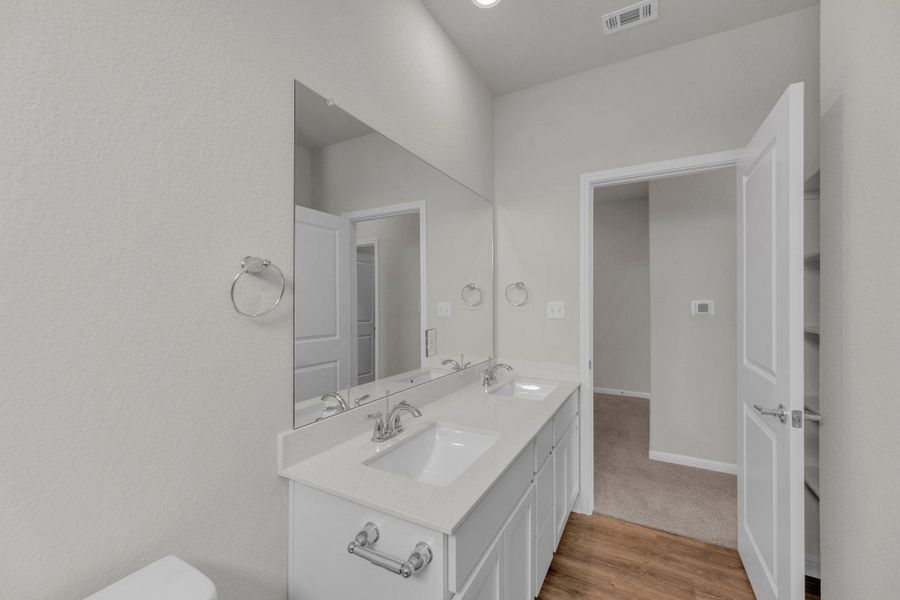 Bathroom with light wood finished floors and double vanity