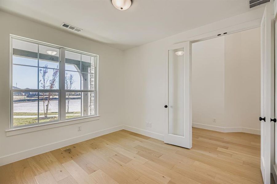 Spare room featuring light wood finished floors and a water view Spare room featuring light wood finished floors and a water view