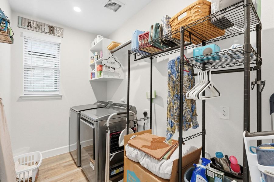 Dedicated utility space featuring light wood-finish flooring