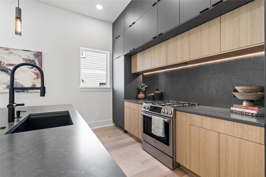 Every detail in this chef’s kitchen has been dialed in with purpose—from the soft undercabinet lighting that highlights the textured stone backsplash to the precision of Bosch appliances integrated seamlessly into the cabinetry. The matte black fixtures echo the home’s modern edge, while warm oak tones keep the space grounded. It’s a design that doesn’t ask for attention—it earns it. Every detail in this chef’s kitchen has been dialed in with purpose—from the soft undercabinet lighting that highlights the textured stone backsplash to the precision of Bosch appliances integrated seamlessly into the cabinetry. The matte black fixtures echo the home’s modern edge, while warm oak tones keep the space grounded. It’s a design that doesn’t ask for attention—it earns it.