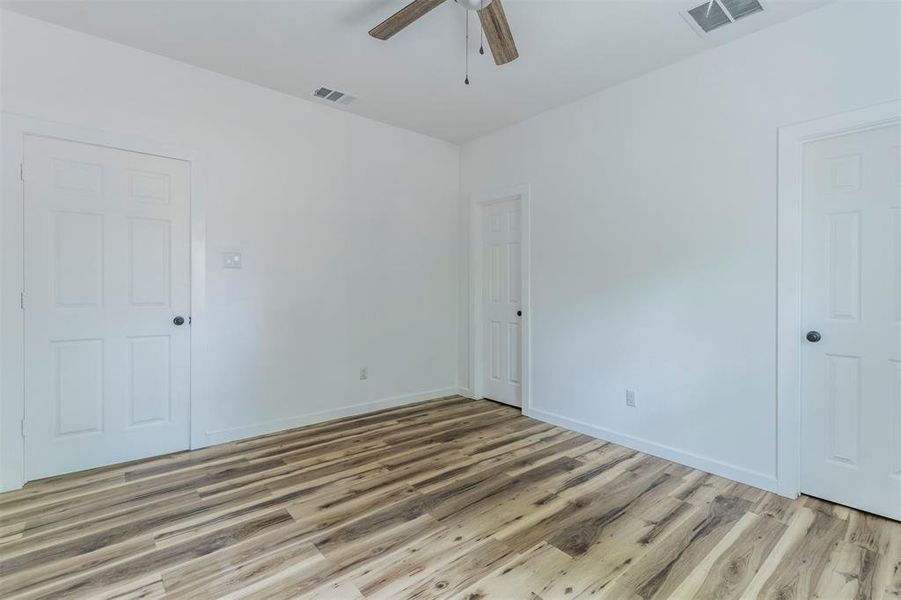 Spare room featuring a ceiling fan, light wood-style floors, and baseboards Spare room featuring a ceiling fan, light wood-style floors, and baseboards
