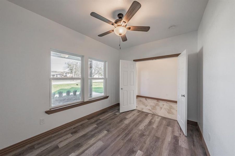 Unfurnished bedroom featuring wood finished floors, a ceiling fan, and baseboards