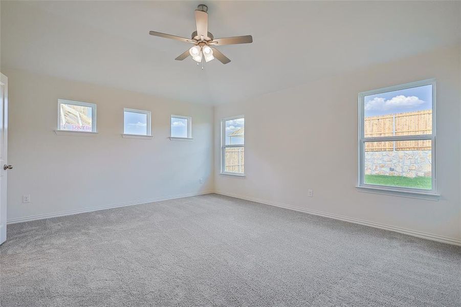 Unfurnished room featuring lofted ceiling, light colored carpet, and ceiling fan