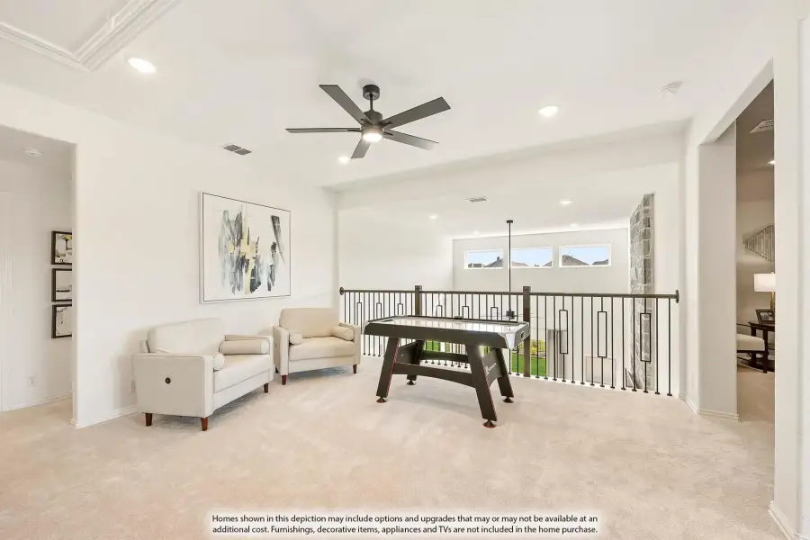 Upstairs loft game room with air hockey table, seating area, ceiling fan, and open railing overlooking lower level