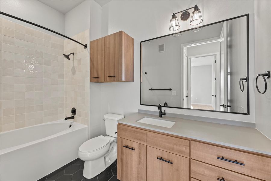 Full bathroom with tiled shower / bath, tile patterned floors, toilet, and vanity