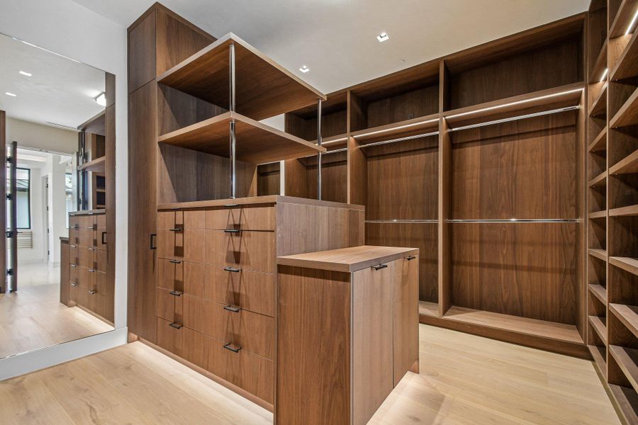 Custom wood cabinetry and integrated shelving maximize storage within this master wardrobe area. Custom wood cabinetry and integrated shelving maximize storage within this master wardrobe area.