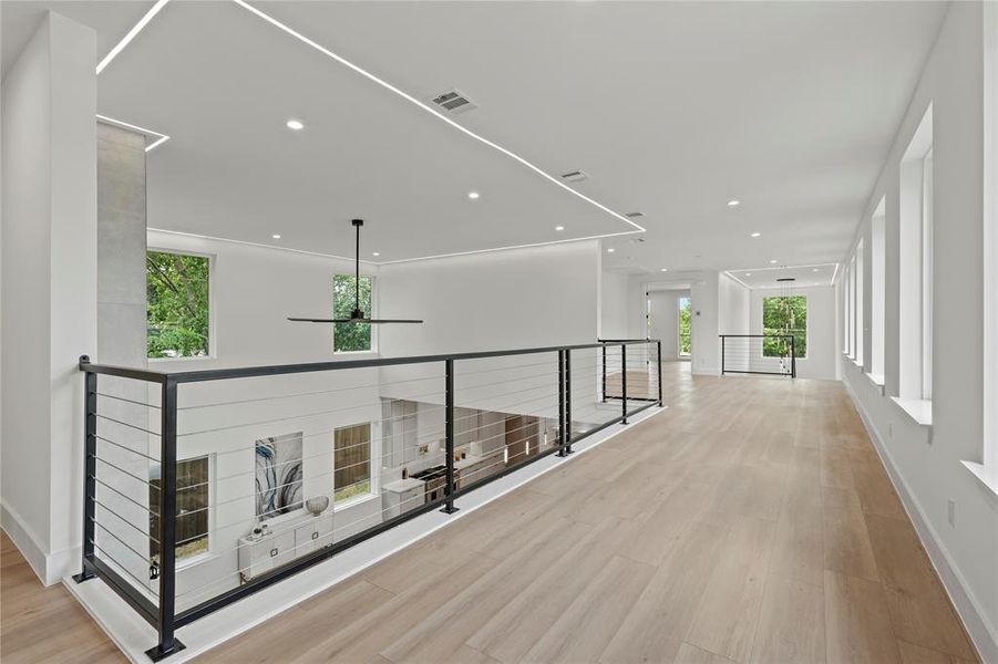 Hall featuring an upstairs landing, wood finished floors, healthy amount of natural light, and recessed lighting