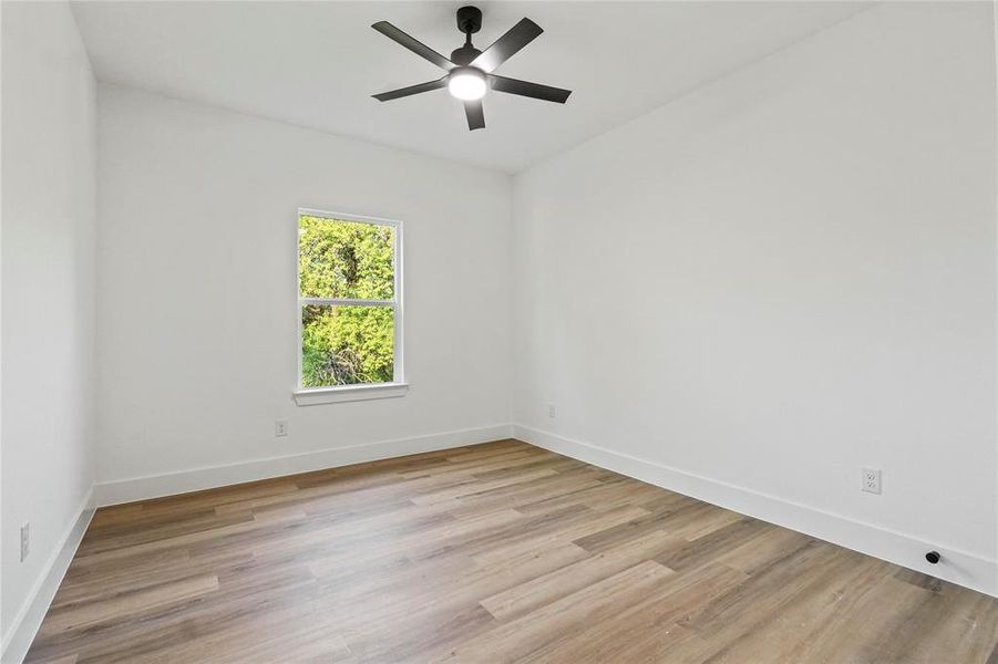 Spare room featuring light wood-type flooring and a ceiling fan