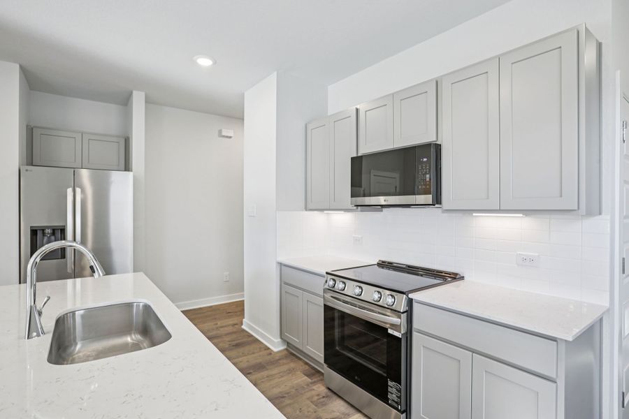 A kitchen with white cabinets.